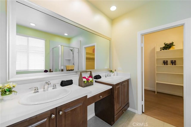 bathroom featuring tile patterned flooring, vanity, and a shower with shower door