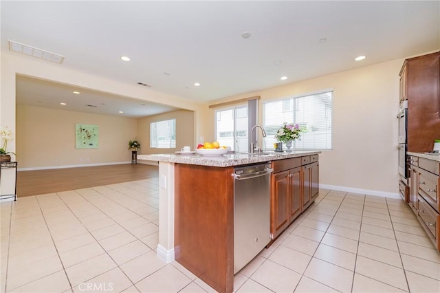 kitchen with appliances with stainless steel finishes, a wealth of natural light, sink, and light tile patterned floors