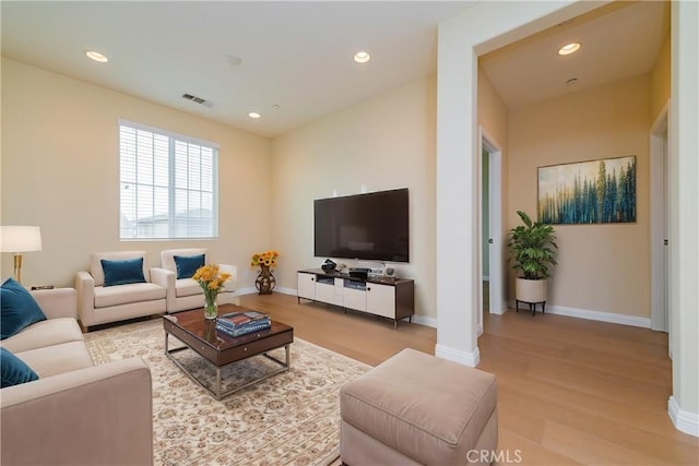 living room featuring decorative columns and light wood-type flooring