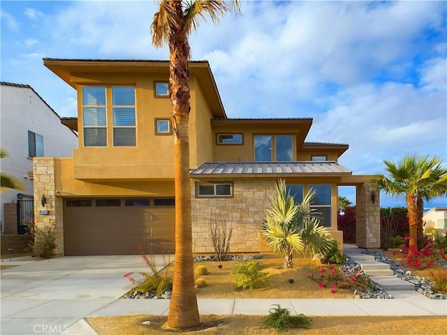 view of front of home featuring stucco siding, a standing seam roof, metal roof, a garage, and stone siding