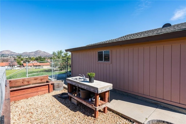 view of patio / terrace featuring a gate, a mountain view, and fence