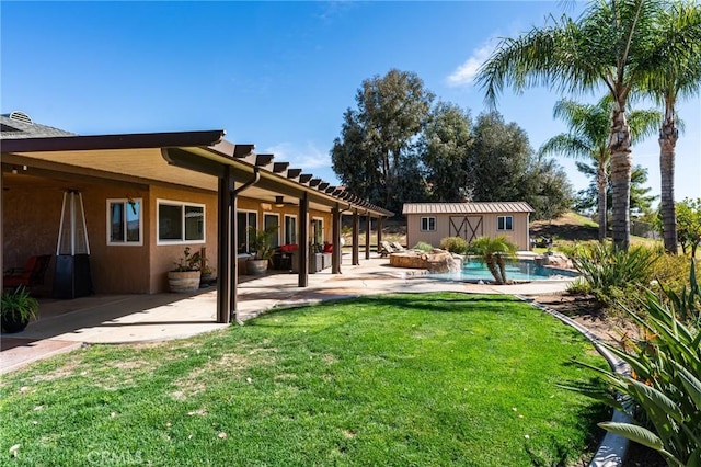 view of yard with an outdoor pool, an outbuilding, and a patio