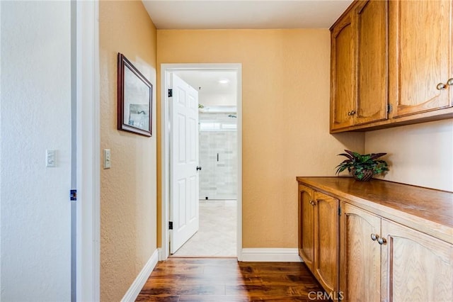 hall with dark wood finished floors and baseboards