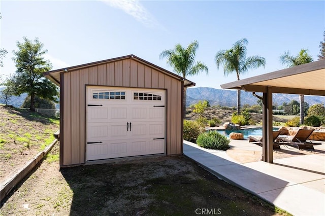 detached garage featuring a mountain view and an outdoor pool