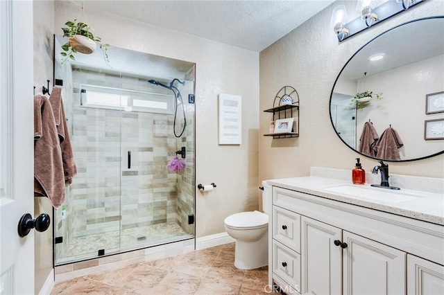 full bath featuring toilet, a textured ceiling, a shower stall, vanity, and baseboards