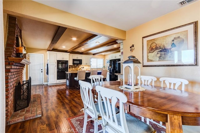 dining space featuring dark wood-style floors, a fireplace, recessed lighting, visible vents, and beamed ceiling