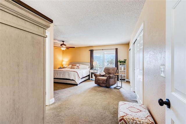 bedroom with a textured ceiling, carpet flooring, a ceiling fan, and baseboards