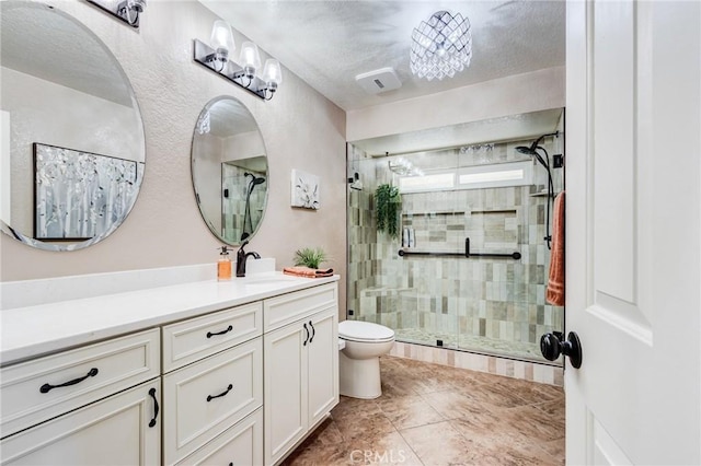 bathroom featuring visible vents, a stall shower, vanity, and toilet