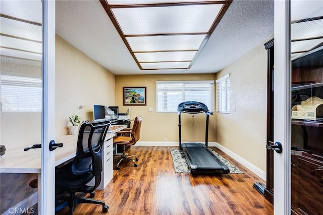 office area with baseboards and wood finished floors