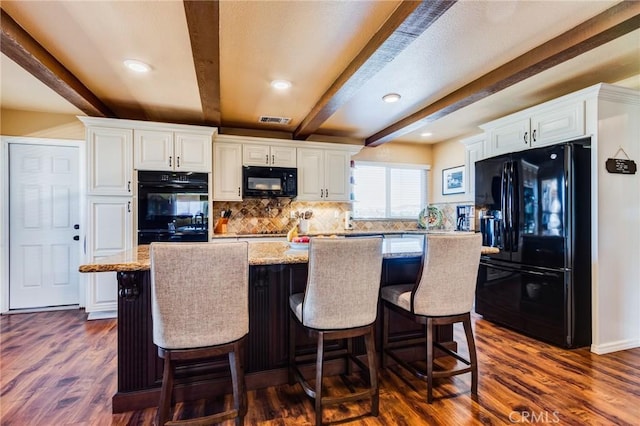 kitchen with dark wood-style flooring, beam ceiling, visible vents, and black appliances