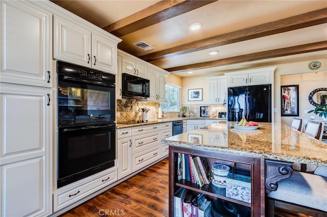 kitchen featuring white cabinets, light stone counters, dark wood-style flooring, black appliances, and beam ceiling