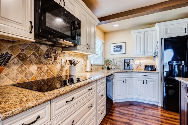 kitchen featuring black appliances, dark wood-type flooring, white cabinetry, and light stone countertops