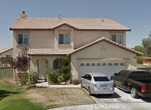 mediterranean / spanish home with a chimney, stucco siding, concrete driveway, an attached garage, and a tiled roof