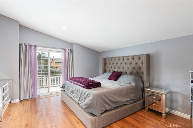 bedroom featuring light hardwood / wood-style flooring, access to outside, and vaulted ceiling