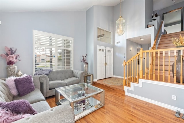 living room with hardwood / wood-style flooring and high vaulted ceiling