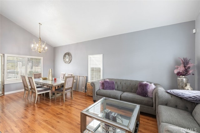 living room with hardwood / wood-style flooring, high vaulted ceiling, and a notable chandelier