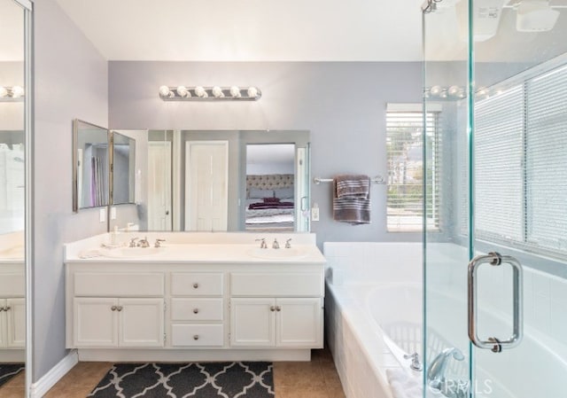 bathroom featuring tile patterned flooring, vanity, and tiled bath