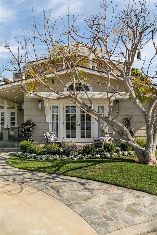 exterior space with a patio, a front lawn, and french doors