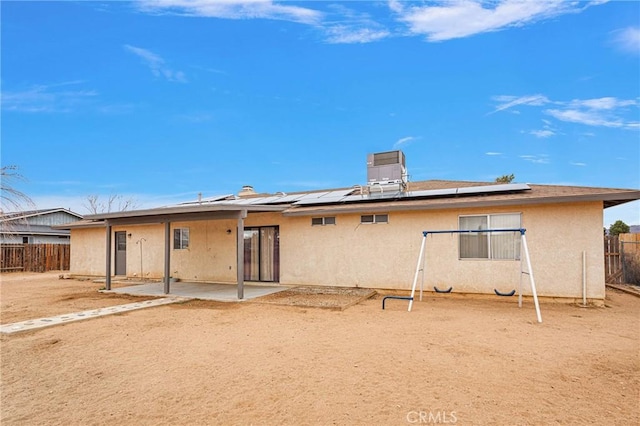 back of house featuring a patio area and solar panels