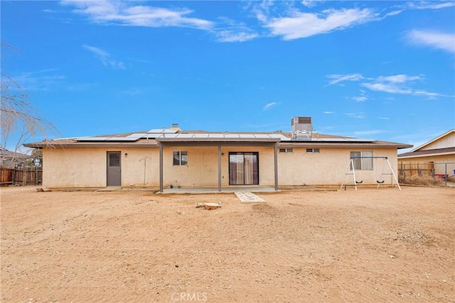 back of property with central AC unit and solar panels