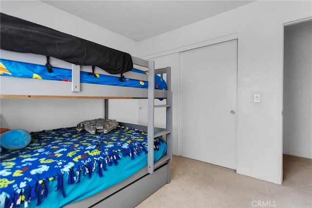 bedroom featuring light carpet and a closet