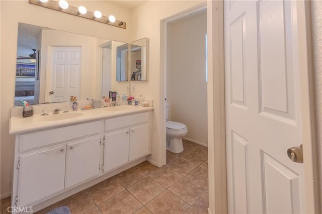 bathroom featuring vanity, ceiling fan, tile patterned floors, and toilet