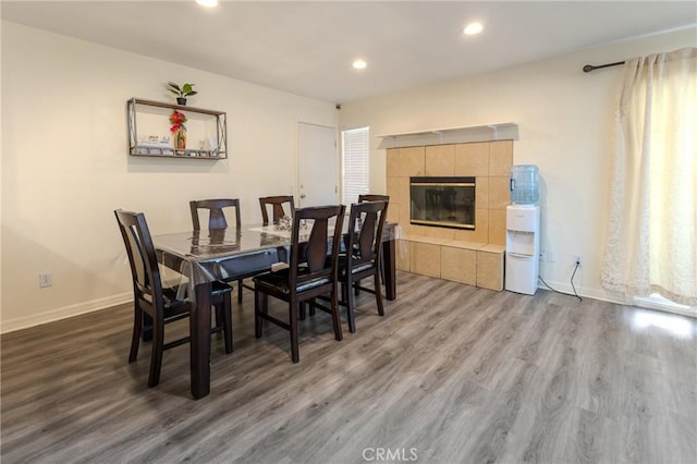 dining area with wood-type flooring and a fireplace