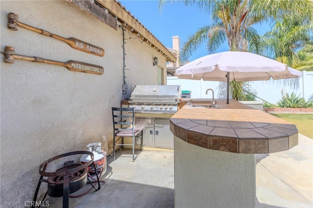 view of patio with a grill, exterior kitchen, and sink