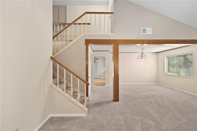 stairway featuring carpet flooring, a chandelier, and high vaulted ceiling