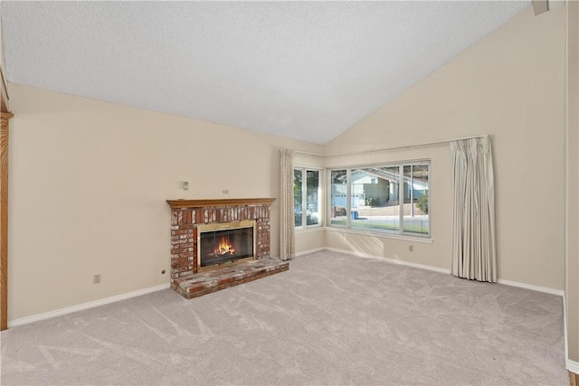 unfurnished living room with high vaulted ceiling, a brick fireplace, light colored carpet, and a textured ceiling