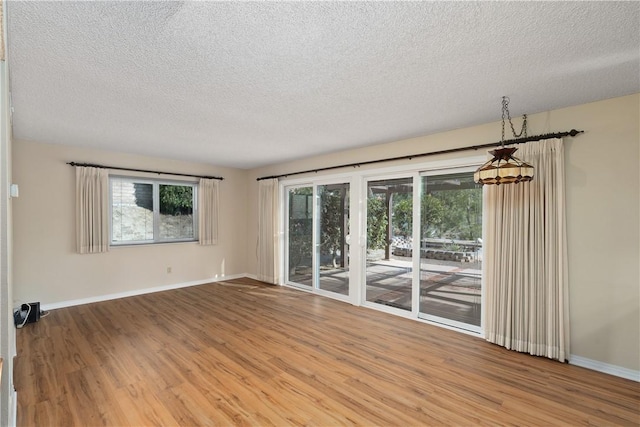 empty room with hardwood / wood-style flooring and a textured ceiling