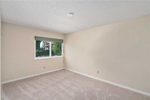 empty room with light carpet and a textured ceiling