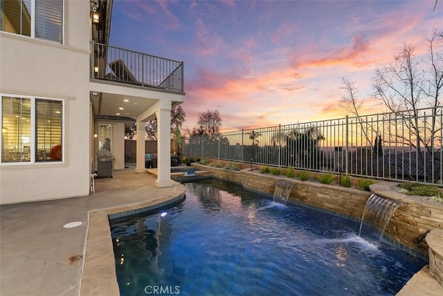 pool at dusk with a patio, a fenced backyard, and a fenced in pool