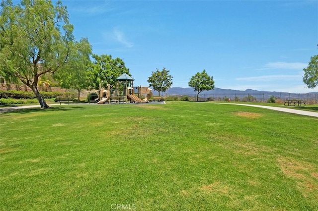 view of home's community with playground community, a yard, and a mountain view