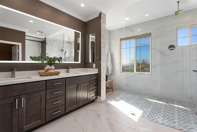 full bath featuring double vanity, marble finish floor, walk in shower, and a sink