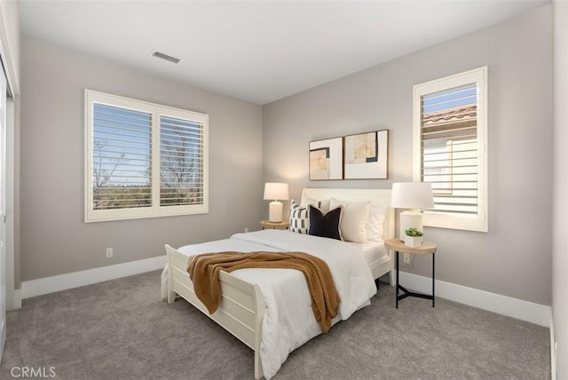 carpeted bedroom featuring baseboards and visible vents