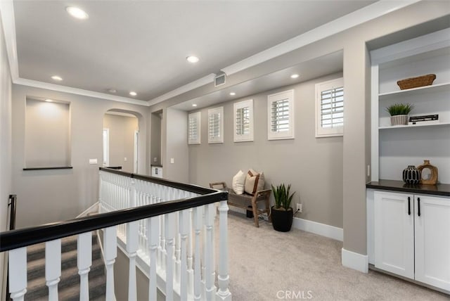 hallway featuring recessed lighting, an upstairs landing, arched walkways, and light carpet