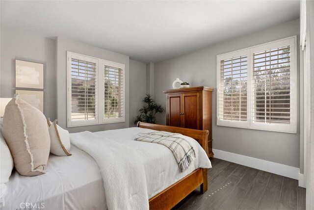 bedroom featuring dark wood-type flooring and baseboards