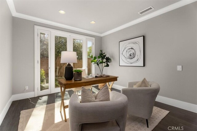 office space featuring visible vents, baseboards, wood finished floors, and ornamental molding