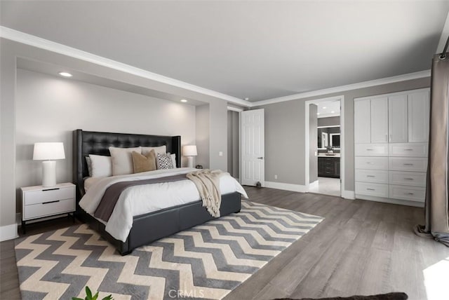 bedroom featuring ornamental molding, wood finished floors, recessed lighting, connected bathroom, and baseboards