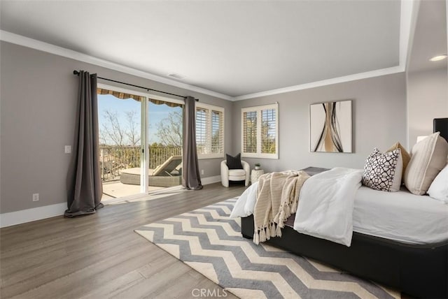 bedroom with wood finished floors, crown molding, baseboards, and access to outside