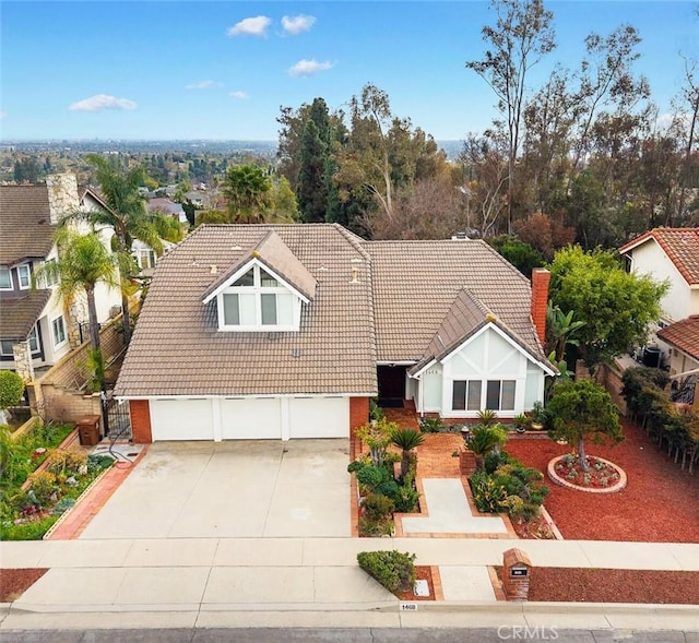 view of front of house featuring a garage, a residential view, concrete driveway, and a tile roof