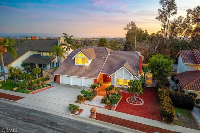 view of front of home featuring a garage, driveway, and a tile roof