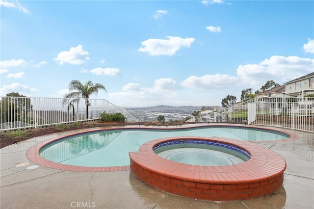 view of swimming pool featuring an in ground hot tub and a mountain view