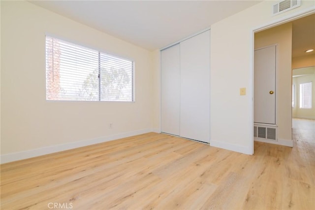 unfurnished bedroom with a closet and light wood-type flooring