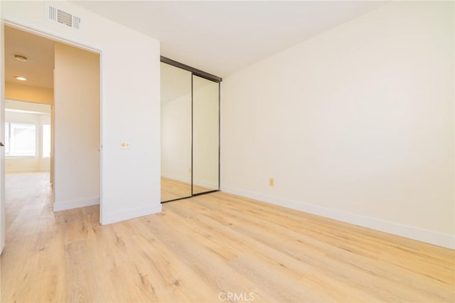 unfurnished bedroom featuring a closet and light hardwood / wood-style flooring