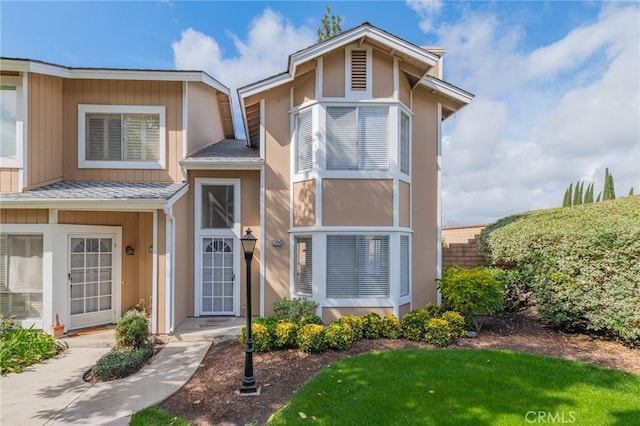 townhome / multi-family property with a shingled roof