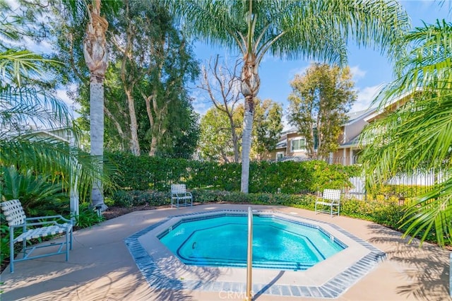 view of swimming pool featuring a hot tub and a patio area