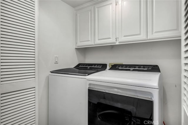 laundry area featuring cabinets and washer and clothes dryer