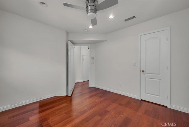 spare room featuring dark wood-type flooring and ceiling fan